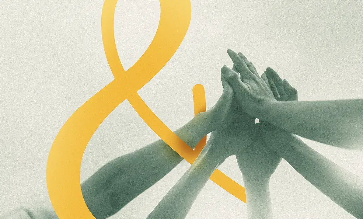 plusieurs mains se joignent devant un ciel clair, avec une esperluette jaune, métaphore de formation soft skills participative en entreprise